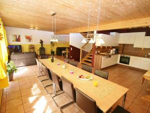 a kitchen and dining room with a long table and chairs at Spacious Chalet in Piesendorf with Sauna in Piesendorf