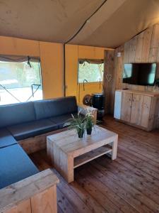 エーペにあるLuxe Safaritent voor het hele gezin I 6 personenのソファとコーヒーテーブルのあるリビングルーム