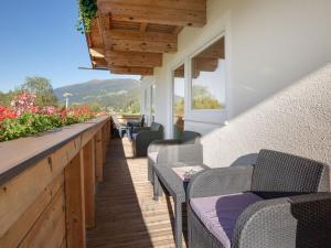 a row of chairs on a balcony with flowers at Upscale Apartment in Salzburg with terrace and country views in Hollersbach im Pinzgau