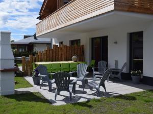 a patio with chairs and a green table at Modern Holiday Home in Leogang with Private Sauna in Leogang