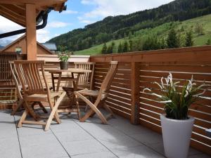 a patio with a table and chairs on a deck at Modern Holiday Home in Leogang with Private Sauna in Leogang