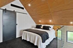 Un dormitorio con una cama grande con techo de madera. en Divine on Derby - Christchurch Holiday Home, en Christchurch 27 fotos más
