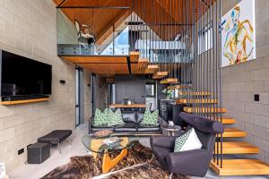 Una sala de estar con muebles y una escalera. en Divine on Derby - Christchurch Holiday Home, en Christchurch