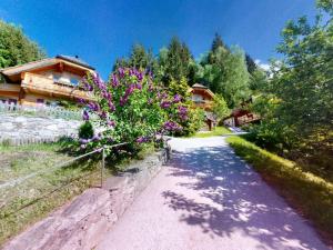 a path in front of a house with purple flowers at Chalet in Neukirchen in Neukirchen am Großvenediger