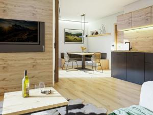 a living room with a table and a kitchen at Bergzeit Apartments right on the ski slope in Saalbach-Hinterglemm