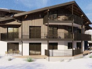aominium building with a balcony with tables and chairs at Bergzeit Apartments right on the ski slope in Saalbach-Hinterglemm