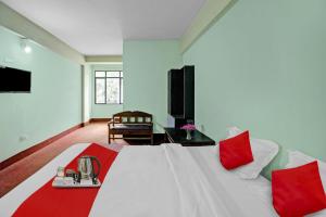 - une chambre avec un lit blanc et des oreillers rouges dans l'établissement Flagship Evergreen Guest House, à Shillong