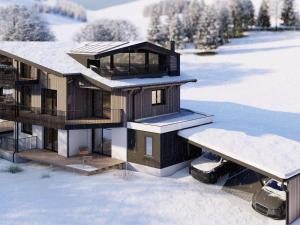 una casa en la nieve con nieve en el suelo en Bergzeit Apartments right on the ski slope, en Saalbach Hinterglemm