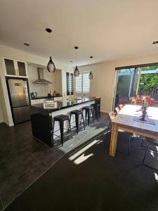 a kitchen with a table and some chairs and a counter at Golden Sands Beachside Cottage in Papamoa