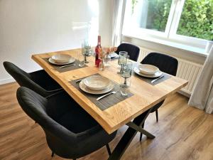 une table en bois avec des assiettes et des verres dans l'établissement WieApart - Ruhig im Grünen, Parkplatz, zw. DUS/CGN, à Leverkusen