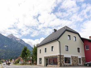 een groot wit gebouw met bergen op de achtergrond bij Gailtaler apartment at an excursion location in Kötschach