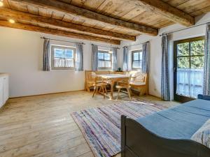 a room with a table and chairs and windows at Almdorf Hochlienz Apartment Alm 30 in Obernussdorf