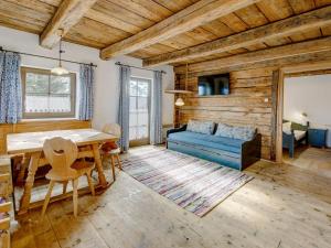 a living room with a table and a blue couch at Almdorf Hochlienz Apartment Alm 30 in Obernussdorf