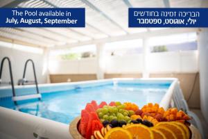 a bowl of fruit in front of a swimming pool at צימר אדל - Zimmer Adel in Yavneʼel