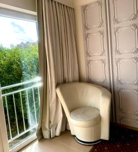 een witte stoel voor een raam bij Tiffany´s Ferienapartments sind alles, außer... gewöhnlich!!! in Timmendorfer Strand