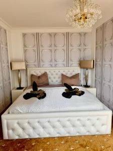 Un dormitorio con una cama blanca con dos sombreros. en Tiffany´s Ferienapartments sind alles, außer... gewöhnlich!!!, en Timmendorfer Strand