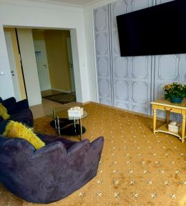 een woonkamer met een bank en een flatscreen-tv bij Tiffany´s Ferienapartments sind alles, außer... gewöhnlich!!! in Timmendorfer Strand
