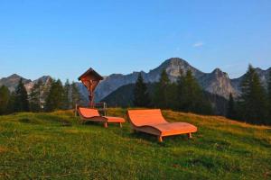 dos sillas en un campo con montañas en el fondo en Chalet Steinbock St Martin am Tennengebirge, en Sankt Martin am Tennengebirge