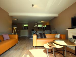 een woonkamer met een oranje bank en een tafel bij Stunning Holiday Home near Forest in Slenaken in Slenaken
