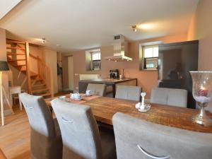 una cucina e una sala da pranzo con tavolo e sedie in legno di Stunning Holiday Home near Forest in Slenaken a Slenaken