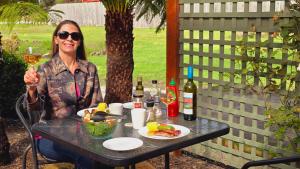 una mujer sentada en una mesa con comida y vino en Sleepy Hollow Hideout - Hideout 1, en Forest