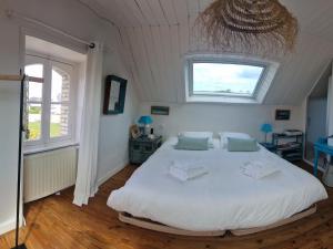 1 dormitorio con 1 cama blanca grande y ventana en Holiday home, flair&premium comfort near the beach, en Plougasnou