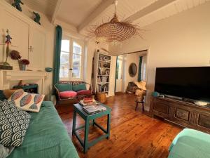 sala de estar con sofá y TV de pantalla plana en Holiday home, flair&premium comfort near the beach, en Plougasnou