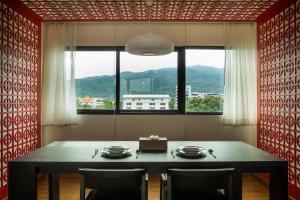 una sala da pranzo con tavolo, sedie e una finestra di S17 Nimman a Chiang Mai