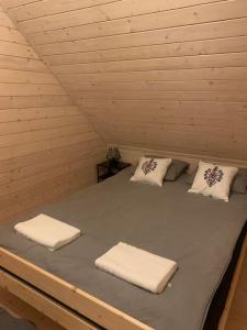 a bed in a room with three towels on it at Srokowa Hacjenda Korbielów in Krzyżowa