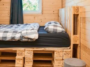 a bed sitting on a wooden platform in a cabin at Holiday home Biker's house in Nadole