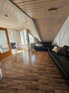 a living room with a black couch and a wooden ceiling at 2 Zimmer Wohnung in Bad Waldsee in Bad Waldsee