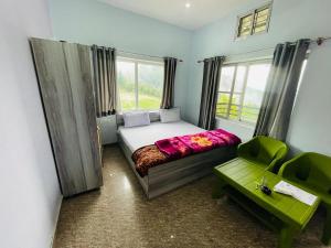 um pequeno quarto com uma cama e uma cadeira verde em Sports Homestay em Lansdowne
