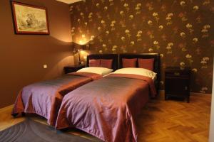 two beds in a bedroom with floral wallpaper at Rezidence Liběchov in Liběchov