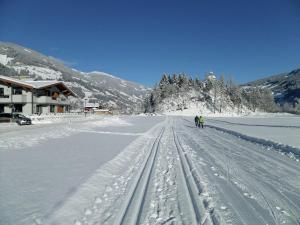 a couple of people riding down a snow covered road at Cozy Apartment near Ski Area in Mayrhofen in Mayrhofen