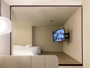 a bedroom with a bed and a tv in a mirror at ST Signature Jalan Besar in Singapore