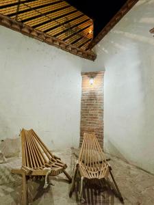 two wooden benches sitting in a room with a brick wall at Casa Madre Santa in Aguascalientes