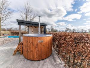 a large wooden barrel sitting next to a building at Spacious farmhouse in Silvolde with garden in Silvolde