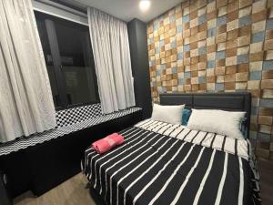 a bedroom with a black and white bed with a window at Princeton Suite @Kuching Airport in Kuching
