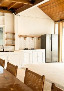 uma cozinha com armários brancos e um frigorífico em Villa Tala em Tua Pejat