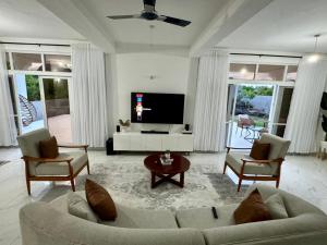 a living room with a couch and chairs and a tv at Mich Homes in Malindi