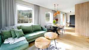 un soggiorno con divano verde e tavolo di RJ Apartament widok na Śnieżkę a Karpacz