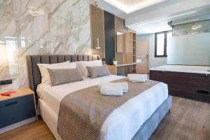 a bedroom with a large bed and a flat screen tv at John & Mary Suites in Rethymno