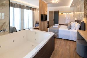 a hotel room with a tub and a bed at John & Mary Suites in Rethymno Town
