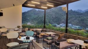 a restaurant with a balcony with tables and chairs at The Bluestone Lodge in Ha Giang