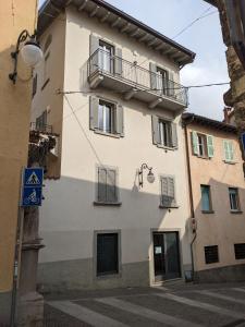 ein weißes Gebäude mit Balkon auf einer Straße in der Unterkunft Mansarda Morlana in Alzano Lombardo