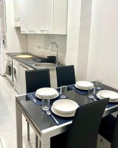einen Esstisch mit Tellern und Stühlen in der Küche in der Unterkunft Casa Bandi in Madrid