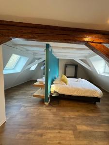 une chambre avec un lit dans un grenier dans l'établissement Les pensées d'Anne & Marie duplex 4/6 Personnes, à Eguisheim