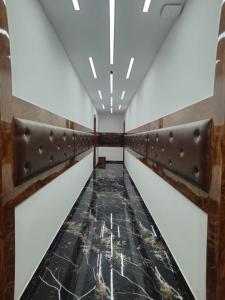 un corridoio con pavimento in marmo nero e ringhiere marroni di wooden suits a Ghaziabad