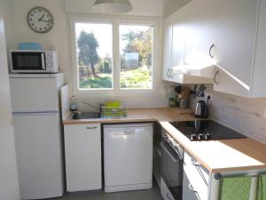 une cuisine avec un réfrigérateur blanc et une fenêtre dans l'établissement Gite Loire et Bois, à Saint-Martin-sur-Ocre