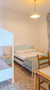 a bedroom with two beds and a table and a chair at Villa Gasparina in Ronchi